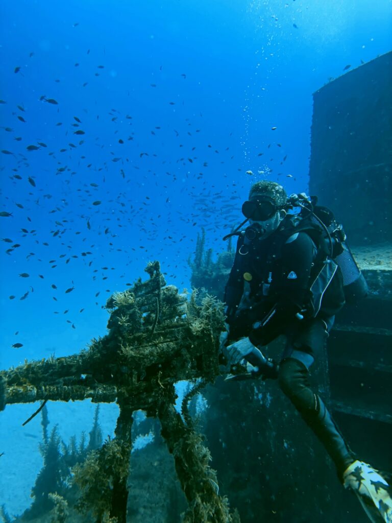 Photo d'un plongeur qui s'amuse avec la mitraillette de l'épave